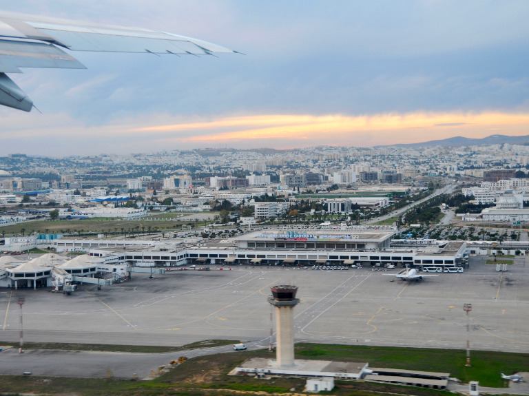 View of Tunis-Carthage airport and the city from a plane window at sunset