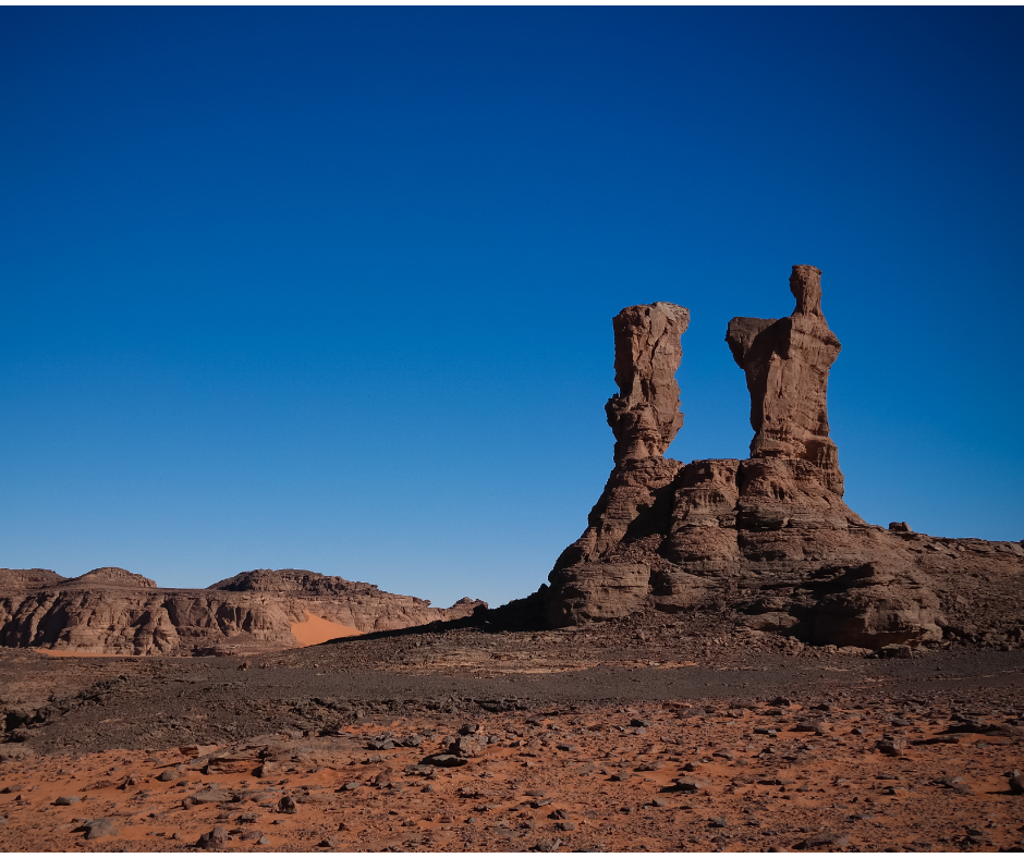 Tall sandstone rock pinnacles under a deep blue sky in Tassili n'Ajjer National Park