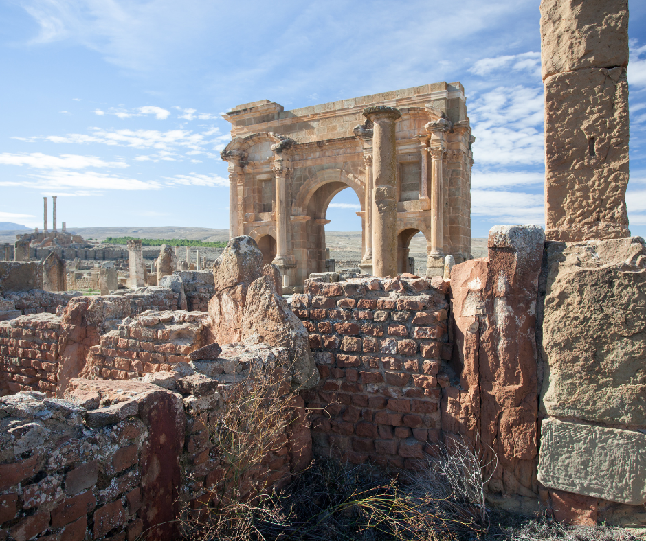 Trajan's Arch among the ruined brick walls of Roman Timgad