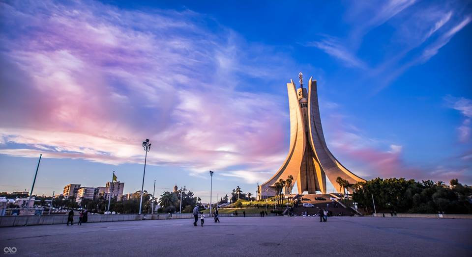 Maqam Echahid in Algiers under a pink and purple evening sky