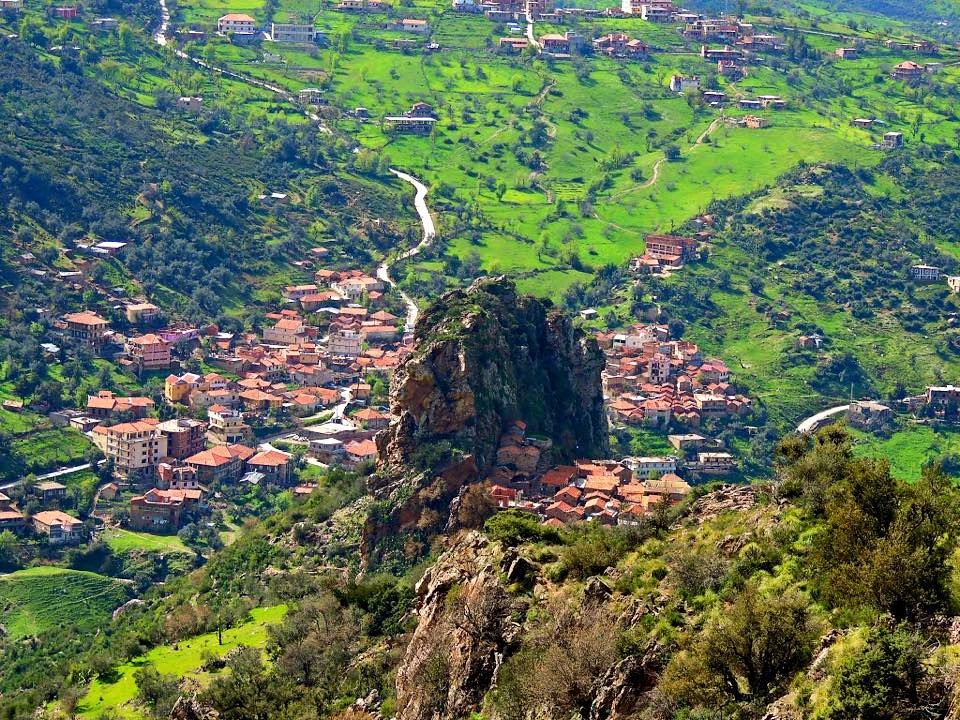 Kabylie mountain village of red-roofed houses spread over green hillsides