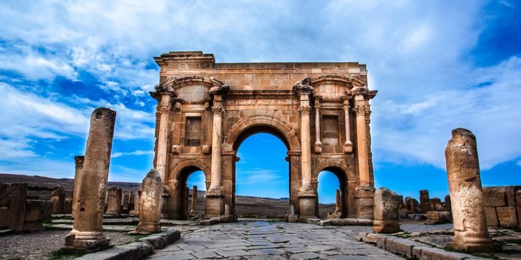 Arch of Trajan at the end of a paved Roman street in Timgad