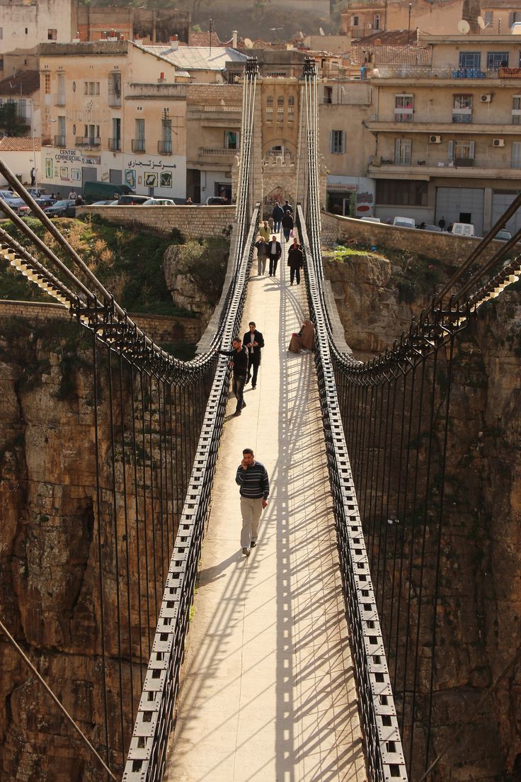 People walking across the narrow Mellah Slimane footbridge above the gorge in Constantine