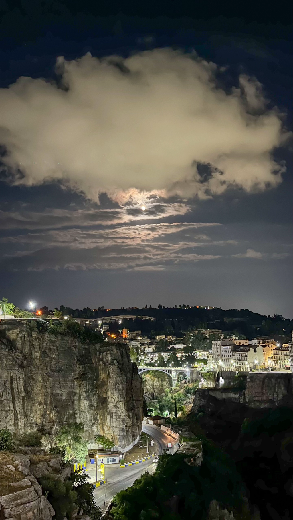 Constantine at night under a cloudy moonlit sky above the Rhumel gorge and bridge