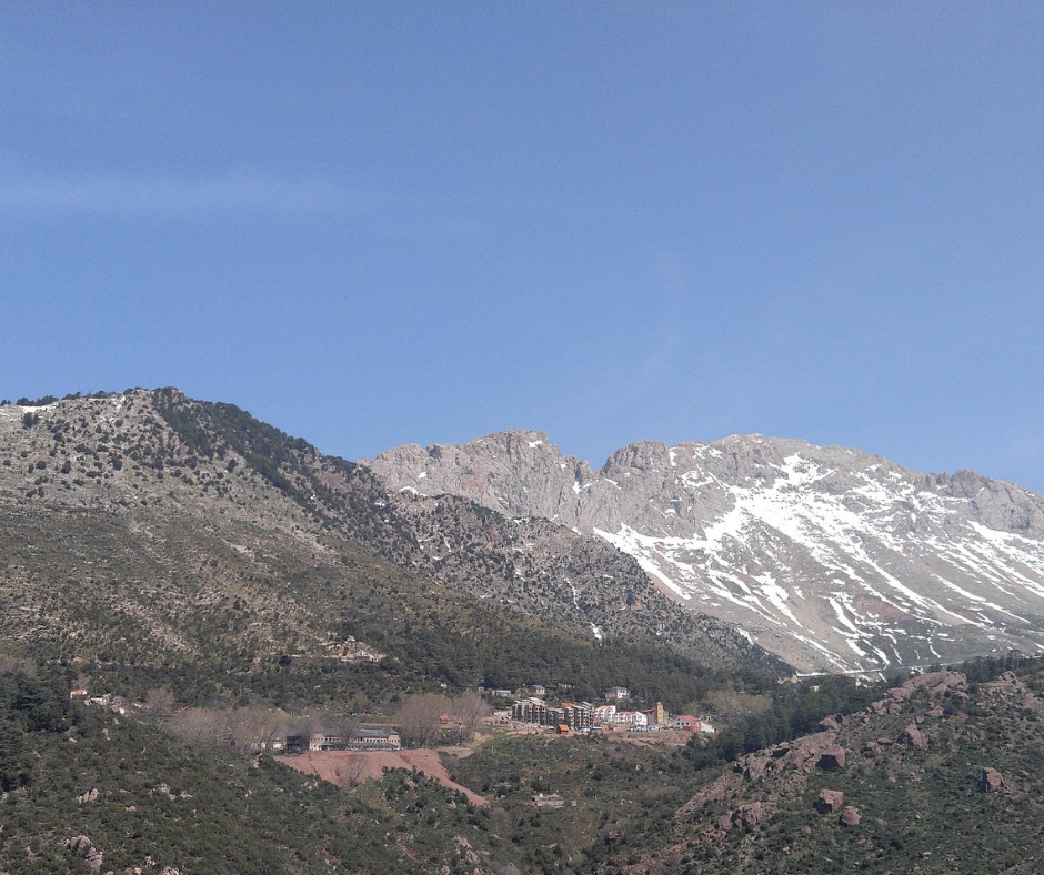 Snow-dusted peaks of the Djurdjura range above a small mountain settlement