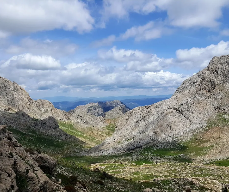 Rocky ridges and green high pastures in the Djurdjura mountains under a cloudy sky