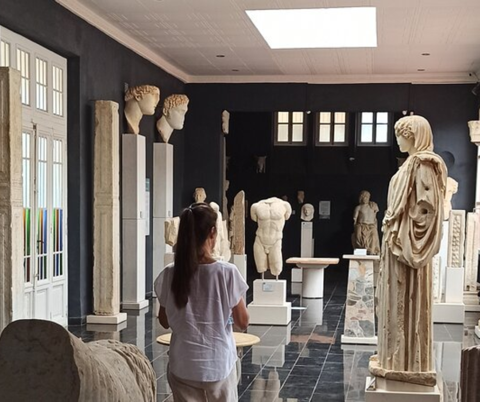 Visitor looking at Roman marble statues and busts in the Cherchell archaeological museum