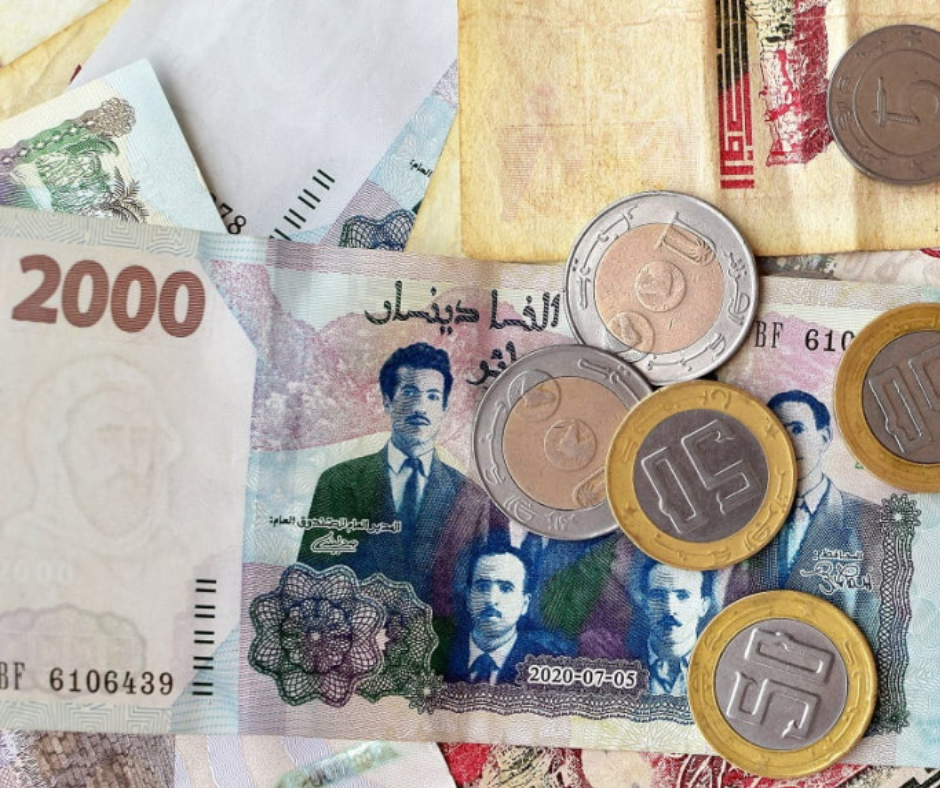 Algerian 2000 dinar banknote and coins lying on a table
