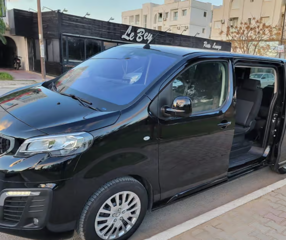 Black private transfer van parked on a street in Oran