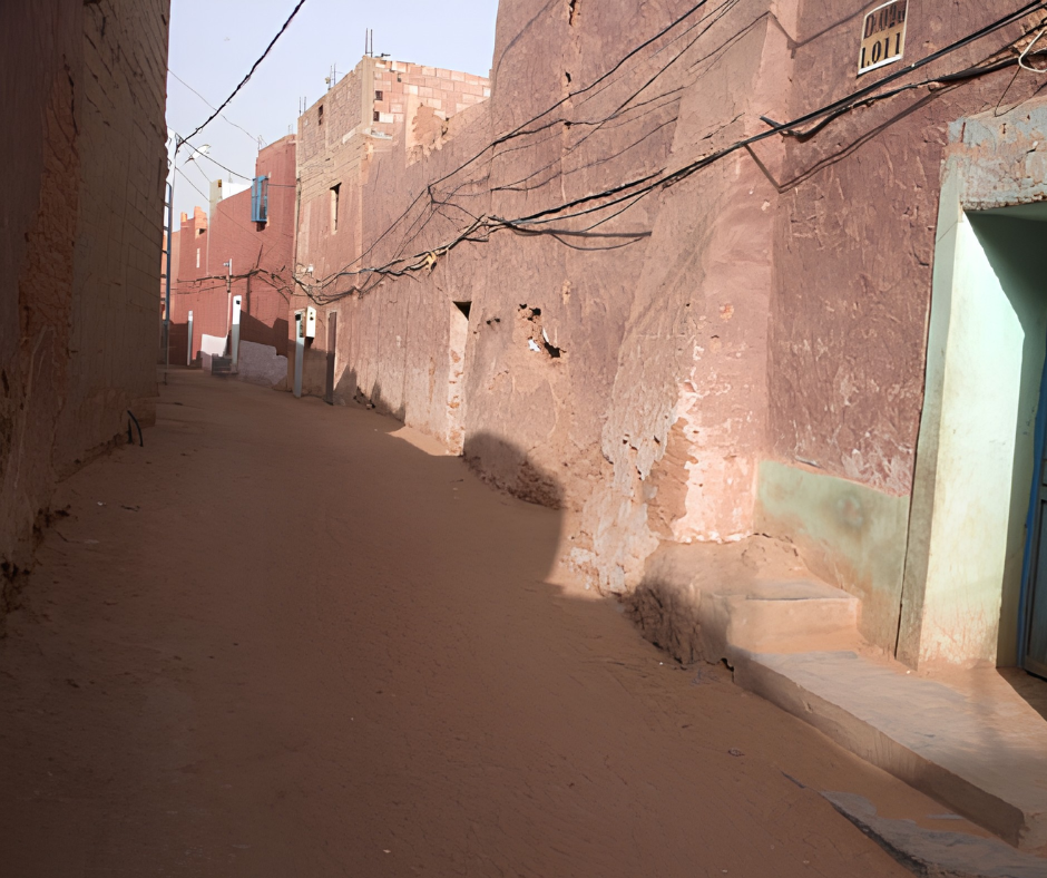 Narrow sandy lane between adobe houses in Timimoun
