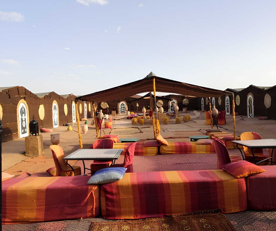 Desert bivouac with cushioned seating and a patterned mud-brick wall